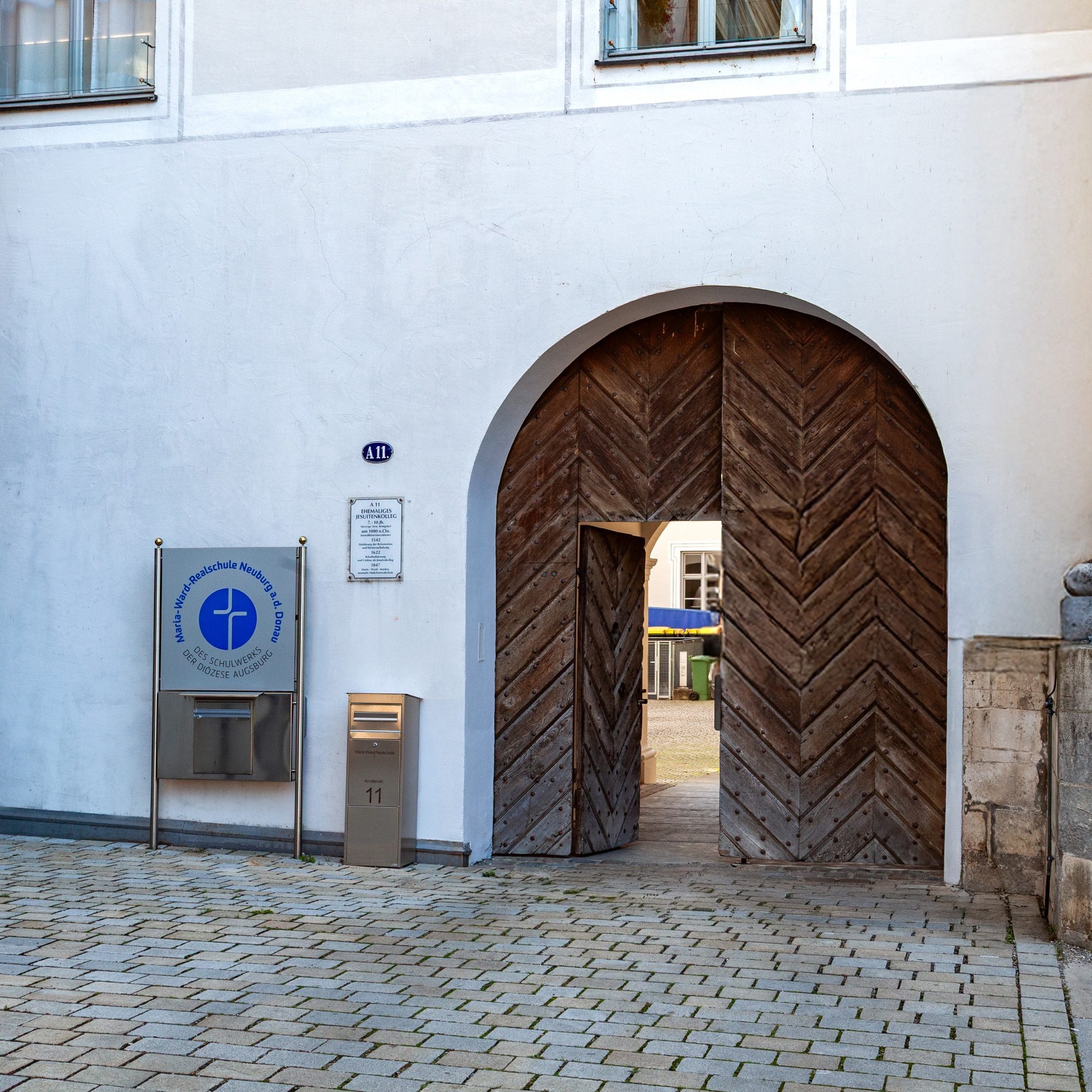 Eingang der Maria-Ward-Realschule Neuburg in der Amalienstraße 11 mit hölzernem Rundbogentor