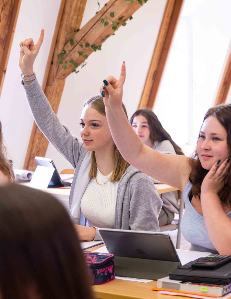 Schülerinnen melden sich im Unterricht, Tablets liegen auf dem Tisch, Maria-Ward-Realschule Neuburg